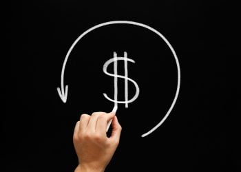 Hand drawing Refund concept - dollar sign in arrow circle with chalk on blackboard. Compensation paid to a customer for returned goods or for over-invoicing. Tax refund - return by the taxation authorities of excess tax paid.