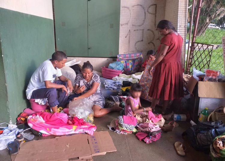 Família recém-chegada da Venezuela, com crianças e uma mulher grávida, se abriga atrás de banheiros na Rodoviária