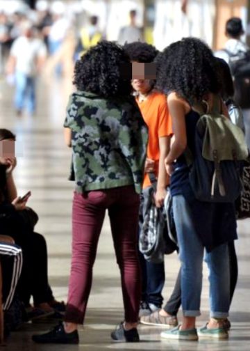 Imagem destaca estudantes negros em ambiente de faculdade
