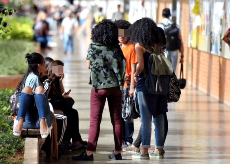 Imagem destaca estudantes negros em ambiente de faculdade