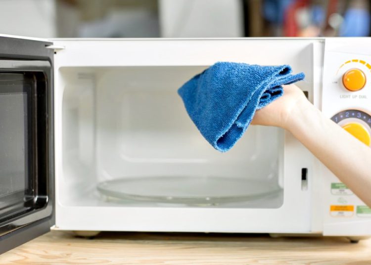 #paratodomundover imagem mostra uma pessoa passando pano no forno microondas