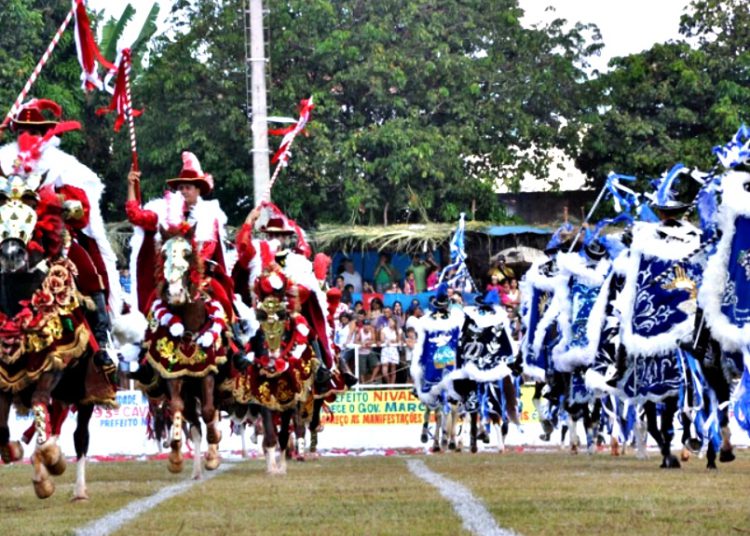 Imagem mostra cavaleiros vestidos de vermelho e azul simulando uma batalha #pratodomundover