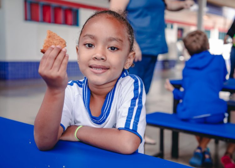 estudante da rede municipal deliciando sua merenda escolar em retorno às aulas