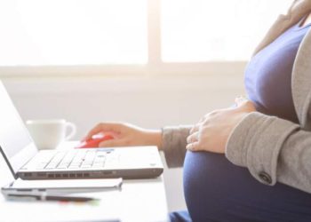 foto de grávida mexendo em laptop, simbolizando o trabalho remoto