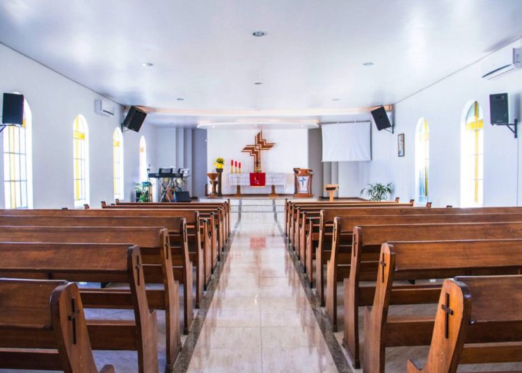 Imagem mostra uma igreja de paredes brancas e bancos de madeira #pratodomundover