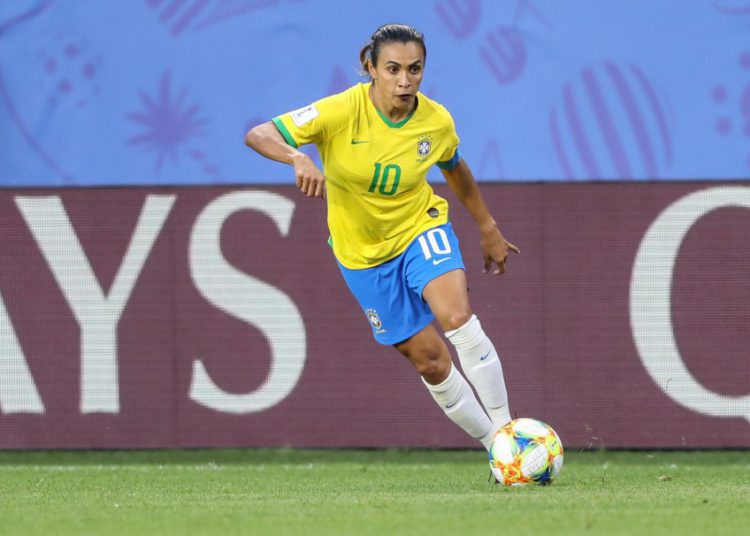 foto da jogadora de futebol marta, vestindo uniforme da seleção: camisa amarela e short azul. Ela usa a camisa de número 10.