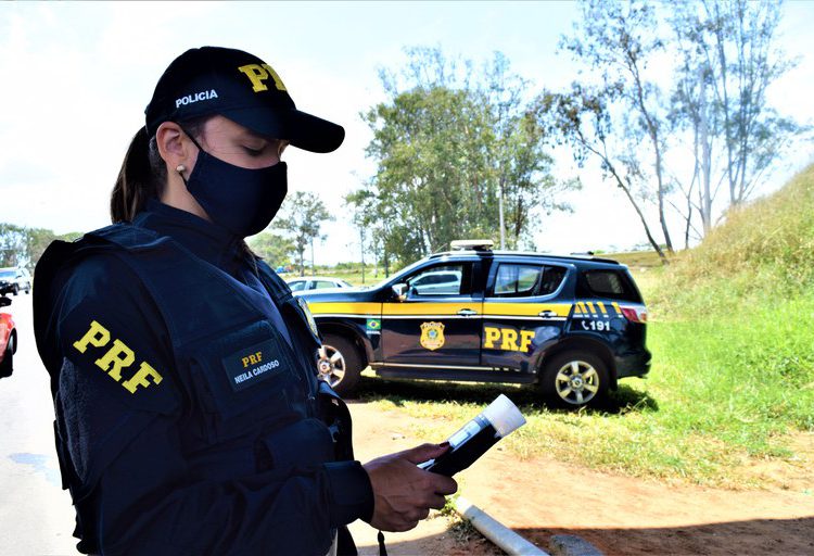 policial rodoviária com bafômetro em mãos, simbolizando a operação carnaval de 2022