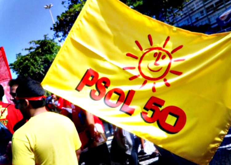 Imagem mostra uma bandeira do PSOL e pessoas caminhando