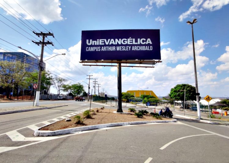 foto da entrada da unievangélica, com placa referenciando o campus
