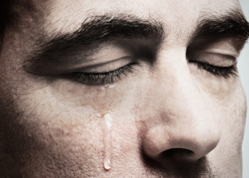 foto de homem chorando, provavelmente sentindo alguma dor