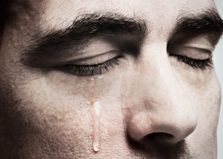 foto de homem chorando, provavelmente sentindo alguma dor