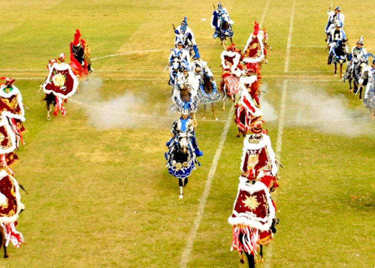 #PraTodoMundoVer: Imagem mostra cavaleiros vetidos com roupas vermelas e azuis, simbolizando uma batalha entre mouros e cristão num campo gramado