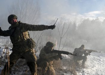 foto da guerra na Ucrânia, com soldado arremessando granada em foco