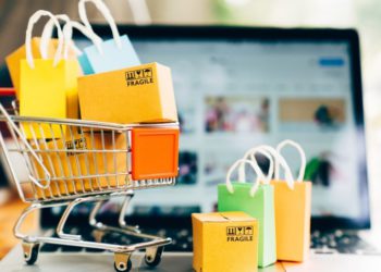 #PraTodoMUndoVer: Imagem mostra uma tela de computador no fundo e um carrinho pequenos de supermercado com sacolinhas de compras