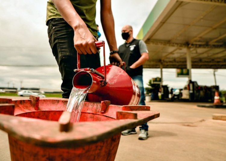 #pratodomundover: Imagem mostra uma gasolina sendo despejada num vasilhame para análise e ao fundo fiscais do inmetro e do procon de anápolis