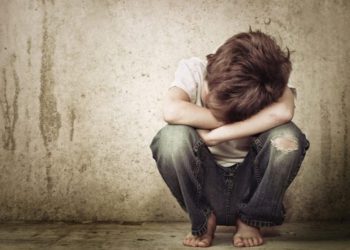 #PraTodoMUndoVer: A imagem mostra uma criança agachada e demonstrando tristeza