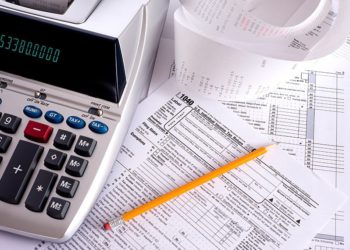 foto de calculadora, lápis e muitos papéis, representando imposto