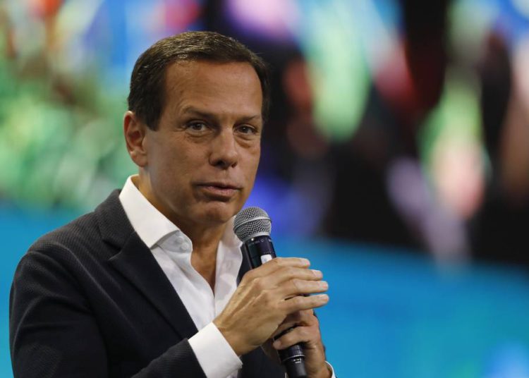foto de joão doria com microfone em mãos, discursando