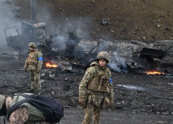 foto de cenário arrasado pela guerra na ucrânia, com três soldados presentes na foto