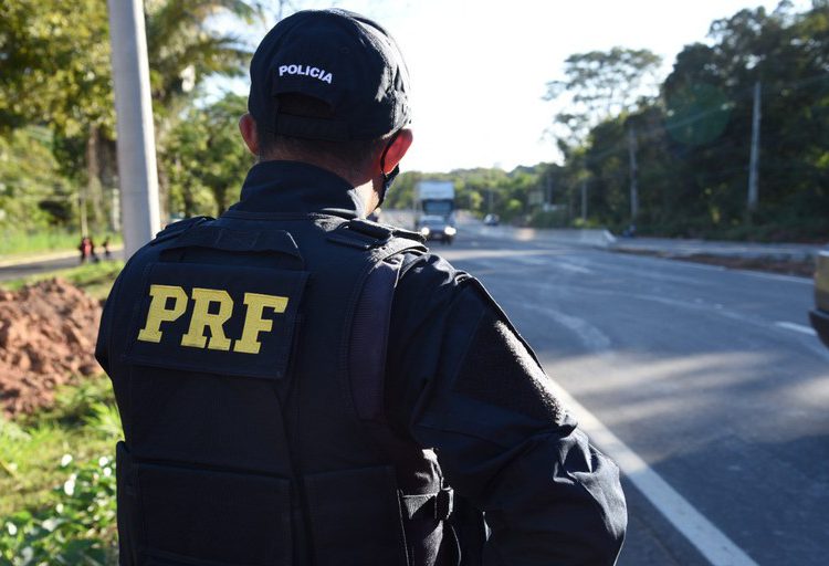 foto de agente da Polícia Rodoviária Federal de costas, observando a rodovia