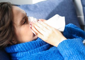 foto de mulher assoando nariz. com resfriado ou gripe