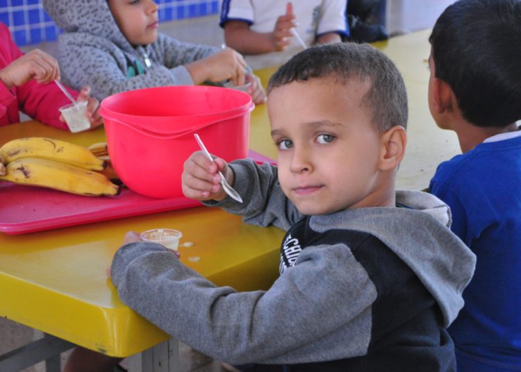 criança degustando merenda escolar