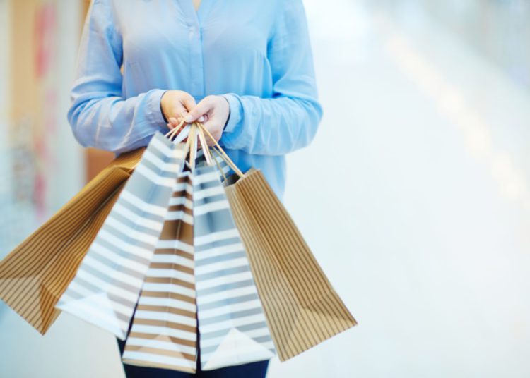 foto de pessoa com sacolas de compras seguradas pelas duas mãos