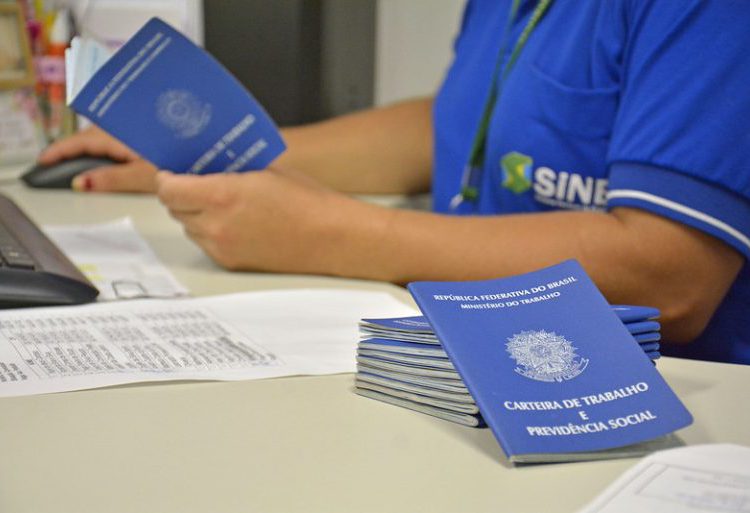 foto de muitas carteiras de trabalho amontoadas, e moça de uniforme conferindo uma a uma