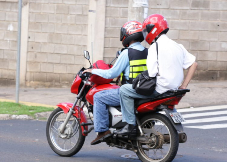 foto de motorista e passageiro andando de motocicleta