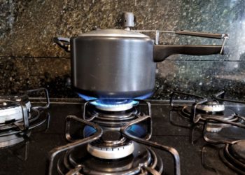 foto de panela de pressão em fogão aceso