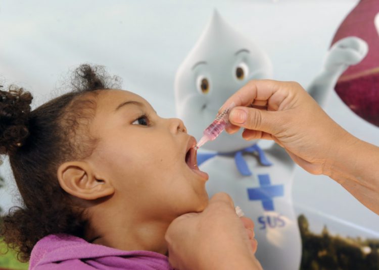 foto de criança recebendo vacina durante a campanha nacional contra a poliomielite
