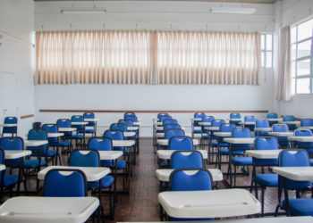 foto de sala de aula vazia, com carteiras azuis enfileiradas