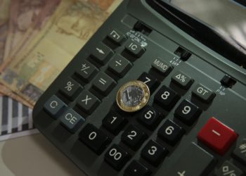 foto de moeda de um real em cima de tecla de calculadora