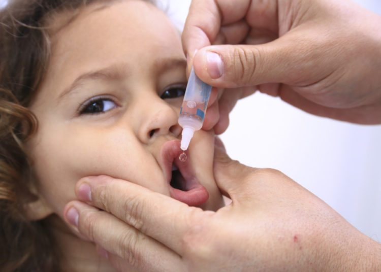 foto de criança recebendo vacina da poliomielite na boca