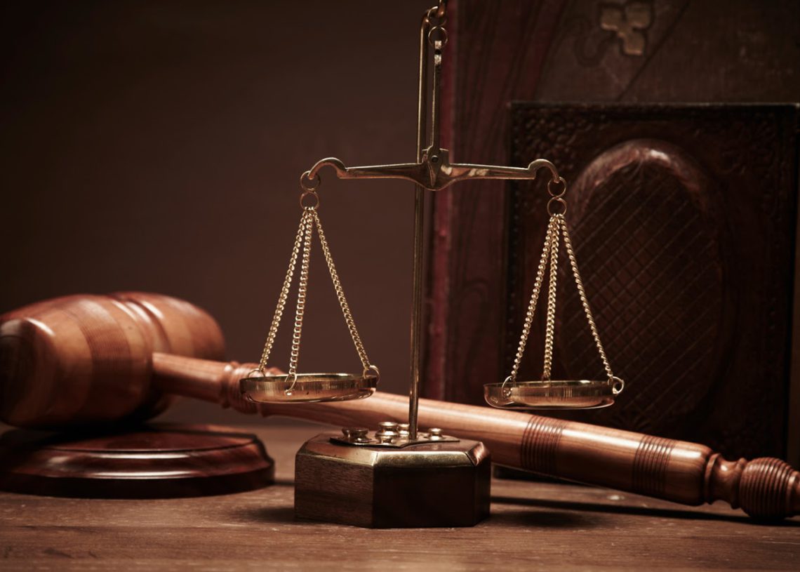 foto de martelo de madeira e balança, representando