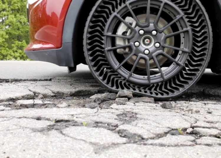 foto do pneu à prova de furos, o UPTIS, passando por cima de rua fragmentada