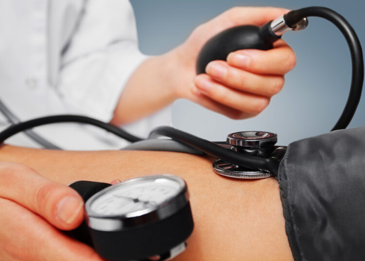 Unrecognizable physician measures blood pressure a patient, close-up