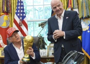Presidente Donald Trump segura o Troféu de Campeão da Copa do Mundo da FIFA enquanto o presidente da FIFA, Gianni Infantino, observa durante um anúncio no Salão Oval da Casa Branca, em Washington. Foto: AP/Jacquelyn Martin.