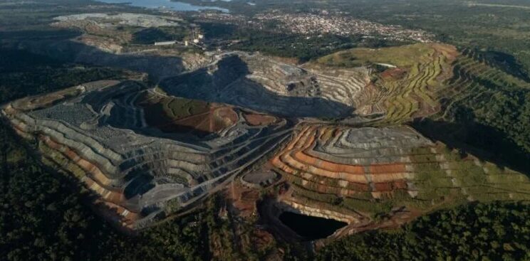 Imagem aérea mostra as cavas abertas pela extração de amianto. Ao fundo, está a cidade de Minaçu. Imagem: Agência Pública / Reprodução.