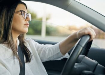 Mulher utilizando óculos ao dirigir – Imagem: Krakenimages.com/Shutterstock