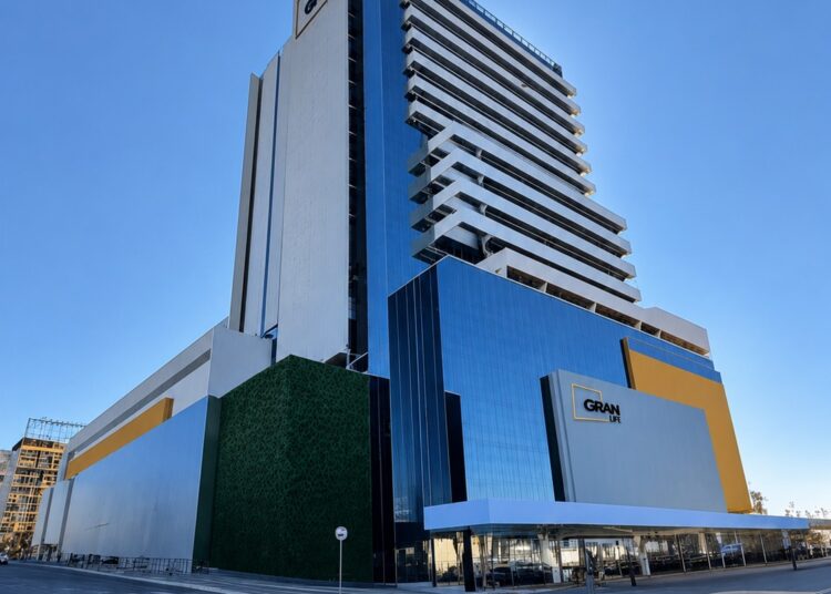 De volta às origens: Fernando Fonseca lidera o maior investimento da história de Anápolis
Depois de construir uma carreira nacional no mercado imobiliário, Fernando Fonseca voltou às origens para liderar o maior investimento privado da história de Anápolis. O Gran Life nasce exatamente onde a cidade começou e simboliza uma nova etapa de desenvolvimento urbano, econômico e humano.
Muito antes de administrar bilhões de reais em empreendimentos espalhados por todo o país, Fernando Fonseca de Oliveira Filho era apenas mais um menino que crescia pelas ruas de Anápolis, observando uma cidade que aprendia a crescer junto com seus moradores.
Foi aqui que estudou. Foi aqui que formou suas primeiras amizades. Foi daqui que saiu para construir uma carreira nacional. E foi justamente para cá que decidiu voltar quando chegou o momento de realizar o projeto mais importante de sua trajetória profissional.
Não se tratava apenas de implantar um grande empreendimento imobiliário. Tratava-se de devolver à cidade parte de tudo aquilo que ela lhe ofereceu.
O resultado dessa decisão pode ser medido em números impressionantes. O Gran Life reúne investimentos que deverão ultrapassar meio bilhão de reais em todas as etapas, tornando-se o maior empreendimento imobiliário privado já realizado em Anápolis. Mas Fernando prefere explicar essa escolha por outro caminho. "A planilha precisava aprovar o investimento. Mas, nesse caso, a planilha e o coração apontaram para o mesmo lugar. Eu sou anapolino. Minha história começou aqui." A frase resume um projeto construído simultaneamente pela razão empresarial e pelo sentimento de pertencimento.
Visão técnica
Ao contrário do que muitos imaginam, um empreendimento dessa dimensão não nasce da intuição.
Antes do primeiro traço arquitetônico, equipes multidisciplinares passaram meses estudando o comportamento econômico da cidade, a demanda por serviços, a dinâmica imobiliária e o potencial de crescimento de Anápolis.
Fernando explica que praticamente todas as decisões foram sustentadas por pesquisas técnicas. O Hospital Sírio-Libanês participou do levantamento das necessidades da saúde regional, enquanto a Brain Inteligência Estratégia — considerada hoje uma das maiores consultorias imobiliárias do país — dimensionou desde o número ideal de apartamentos até o tamanho das salas comerciais e o perfil dos futuros usuários. "Nada foi feito por achismo. Cada ambiente do Gran Life foi pensado com base em indicadores, pesquisas e comportamento de mercado. Esse planejamento transformou o empreendimento em referência nacional antes mesmo de sua conclusão”, resume Fonseca.
Engenharia moderna
Os desafios técnicos começaram muito antes da construção.
O terreno escolhido ocupa um dos espaços mais simbólicos da cidade: a matrícula número um de Anápolis, área pertencente historicamente à Igreja de Sant'Ana. Construir um complexo de quase sessenta mil metros quadrados ao lado de edificações centenárias exigiu soluções pouco comuns na engenharia brasileira.
A escavação profunda foi executada sem provocar danos estruturais aos imóveis vizinhos, resultado que levou o Gran Life a ganhar destaque nacional. Fernando lembra esse momento com evidente satisfação. "Nós conseguimos realizar uma obra gigantesca preservando integralmente o patrimônio histórico ao lado. Não provocamos trincas, deslocamentos nem comprometimento estrutural. Isso exigiu engenharia de alto nível."
O reconhecimento veio em forma de capa da Revista Téchne, uma das publicações técnicas mais respeitadas da engenharia brasileira.
Outro diferencial foi a utilização integral da plataforma BIM, sistema que modela digitalmente toda a construção antes mesmo do início da obra. Mais do que facilitar o trabalho dos engenheiros, a tecnologia aproximou inovação dos próprios operários. Cada pavimento recebeu QR Codes que permitiam ao trabalhador consultar detalhes construtivos diretamente pelo telefone celular. O engenheiro empreendedor garante que "Até o colaborador mais simples podia visualizar em três dimensões exatamente como aquela etapa deveria ser executada."
Novo centro
Se o Gran Life impressiona pelo porte, sua maior contribuição está na transformação urbana que provoca. Localizado onde Anápolis nasceu, o empreendimento tornou-se um dos principais indutores da revitalização do Centro. Fernando acredita que a região possui infraestrutura para viver um novo ciclo de desenvolvimento. "Ali já existem redes de água, energia, transporte coletivo, serviços públicos, hospitais, comércio. O Centro não precisa ser abandonado. Precisa ser revitalizado."
Na plenitude de funcionamento, o complexo deverá reunir aproximadamente seis mil pessoas circulando diariamente e cerca de mil e oitocentos profissionais trabalhando no local. Esse fluxo permanente impulsiona restaurantes, clínicas, farmácias, estacionamentos, escritórios e dezenas de atividades complementares. Mais do que um edifício, Fernando enxerga o Gran Life como um catalisador de investimentos.
Cidade viva
A proposta também rompe com o conceito tradicional de shopping center.
Em vez de grandes lojas de departamento, o empreendimento aposta em um modelo baseado em conveniência, saúde, serviços especializados, bem-estar e gastronomia. Academia, laboratórios, clínicas, consultórios, farmácia, restaurantes, rooftop panorâmico e hospital passam a funcionar como um único ecossistema urbano.
Fernando costuma resumir esse conceito com exemplos simples. "Hoje as pessoas valorizam tempo. Você faz atividade física, almoça, resolve questões de saúde, trabalha, encontra serviços e volta para casa praticamente sem precisar pegar o carro."
Essa lógica acompanha uma tendência consolidada nas principais cidades brasileiras e internacionais, onde moradia, trabalho e lazer deixam de ocupar espaços separados.
A experiência acumulada pela ABL Prime na administração de empreendimentos como Orion Business & Health Complex, Metropolitan e WTC Goiânia serviu como referência para adaptar esse conceito à realidade anapolina.
Futuro próximo
Enquanto acompanha a consolidação do Gran Life, Fernando já olha para novos desafios.
Ele confirma que a empresa prepara outro grande projeto para Anápolis: um bairro planejado que deverá integrar áreas residenciais, comerciais e empresariais. Mas evita falar apenas de edifícios. Prefere discutir o futuro da cidade.
Na sua avaliação, Anápolis reúne características raras no cenário brasileiro. Possui localização privilegiada, um distrito industrial consolidado, universidades fortes, logística nacional e uma população naturalmente empreendedora. "Não tenho dúvida de que Anápolis continuará crescendo de forma exponencial. O papel da iniciativa privada é colaborar para que esse crescimento aconteça com planejamento e qualidade."
A futura implantação do hospital dentro do complexo reforça essa visão. Com estrutura moderna, gestão inspirada no Sírio-Libanês e foco em atendimento regional, o empreendimento amplia a vocação de Anápolis como polo de saúde do Centro-Oeste.
Raízes profundas
Ao final da entrevista, Fernando deixa os indicadores e fala como cidadão.
Recorda que o Gran Life ocupa o terreno onde Anápolis nasceu. Ali, segundo a tradição, a antiga tropa interrompeu a viagem, dando origem ao povoado. "Nossa matrícula é a número um da cidade. Ali começou a história. Construir naquele lugar aumenta nossa responsabilidade."
Essa consciência explica o cuidado dedicado a cada detalhe. Fernando sabe que constrói muito mais do que edifícios: ajuda a escrever um novo capítulo da cidade onde nasceu.
Questionado sobre o principal ensinamento para jovens empreendedores, fala de perseverança. "Empreendimentos importantes levam anos para nascer. Exigem resiliência, competência e um grande time. Todos os dias você coloca um tijolo. Depois, percebe que construiu uma história."
Talvez essa seja a melhor definição para o Gran Life. Mais do que o maior investimento privado de Anápolis, representa o compromisso de um filho que voltou para casa para construir o futuro da sua cidade.