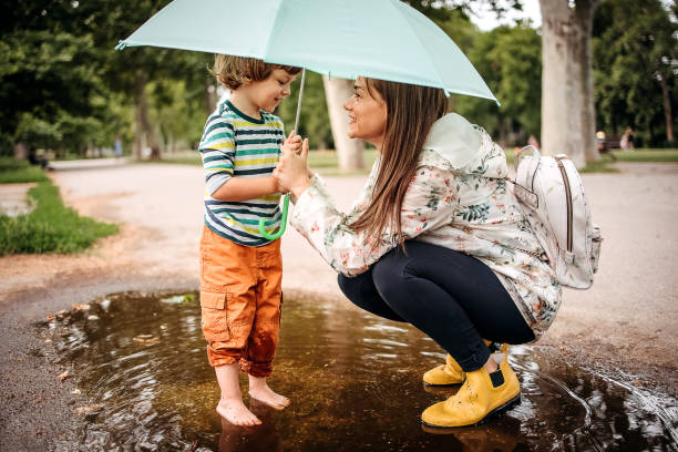 Happy family playing in the street after a rain.