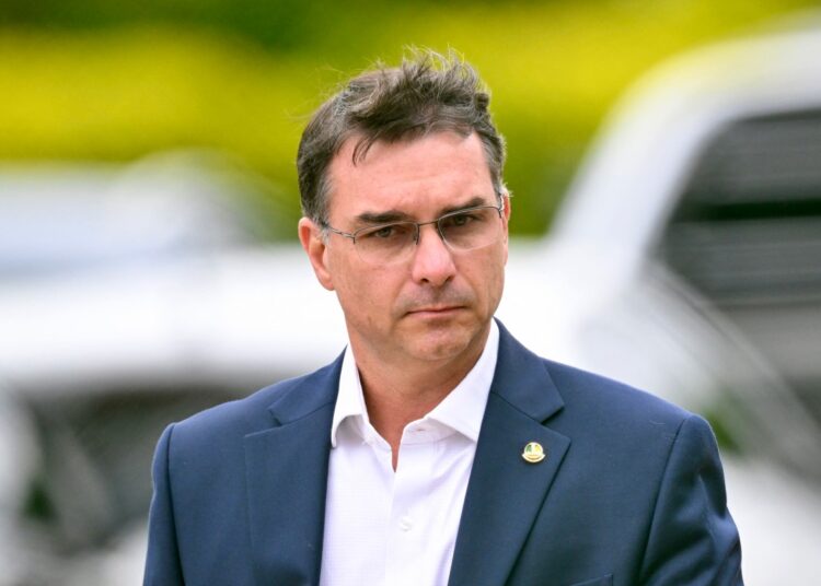 (FILES) Senator Flavio Bolsonaro, son of former Brazilian president Jair Bolsonaro, leaves the Federal Police headquarters where Bolsonaro is being held, in Brasilia, on November 25, 2025. The eldest son of former Brazilian President Jair Bolsonaro, Senator Flavio Bolsonaro, said on December 5, 2025 that his father had designated him as his political heir, less than a year before the presidential elections in the South American giant. (Photo by Evaristo Sa / AFP)